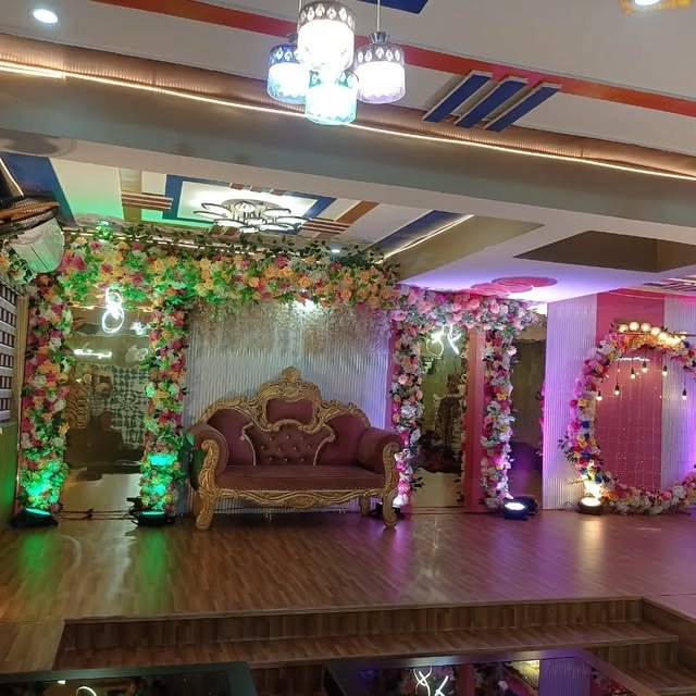 Decorated stage with floral arches and seating inside Shiv Mansa Dhika Banquet